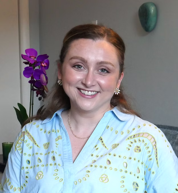 Smiling woman with floral background.