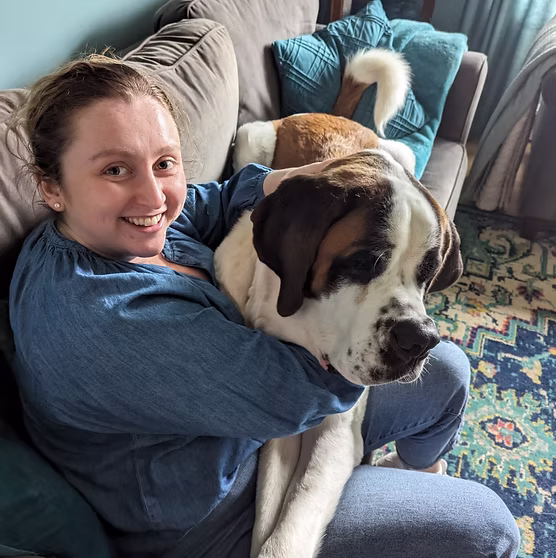 Woman cuddling large dog on couch