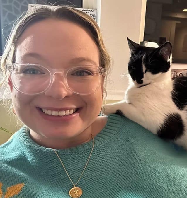 Woman smiling with cat on shoulder